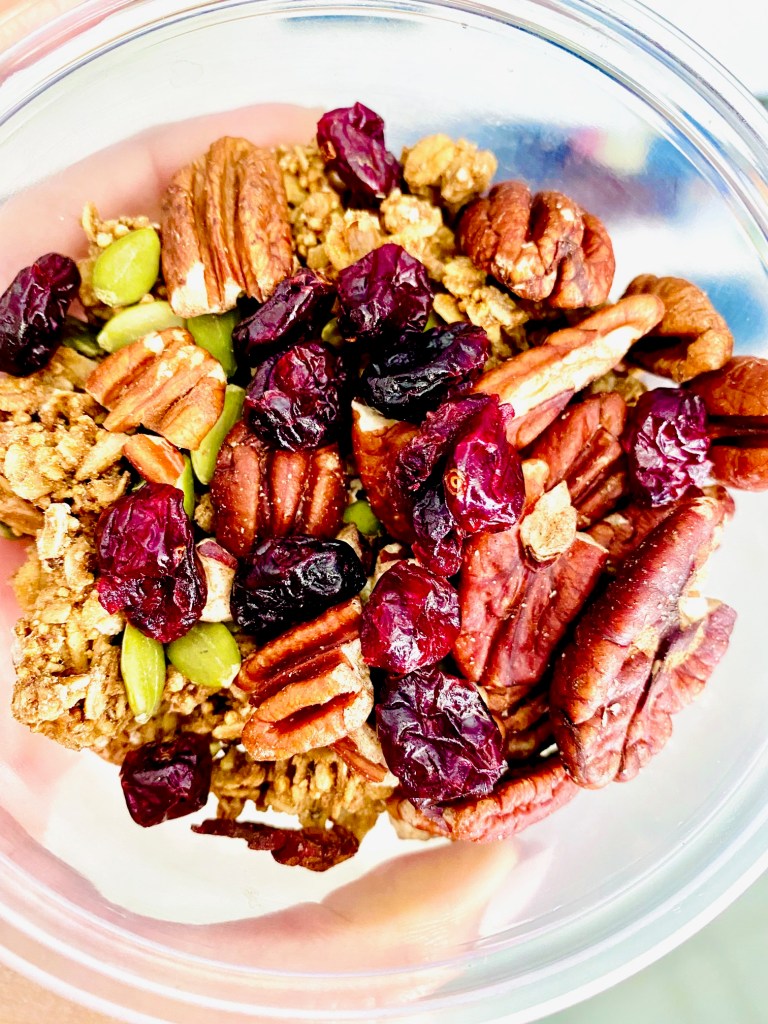 Bowl of homemade muesli with black walnuts, dried cranberries, pumpkin seeds, and granola.