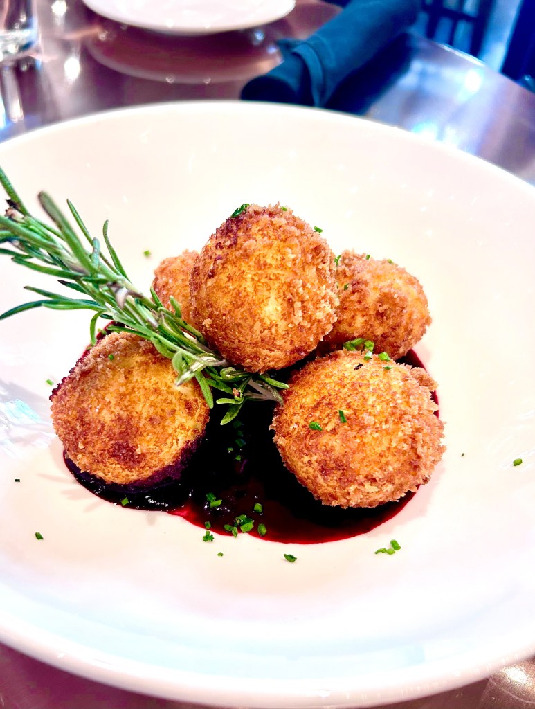 Colorado goat cheese fritters with sage and huckleberry jam plated at Copper Table Restaurant at the Gaylord Rockies